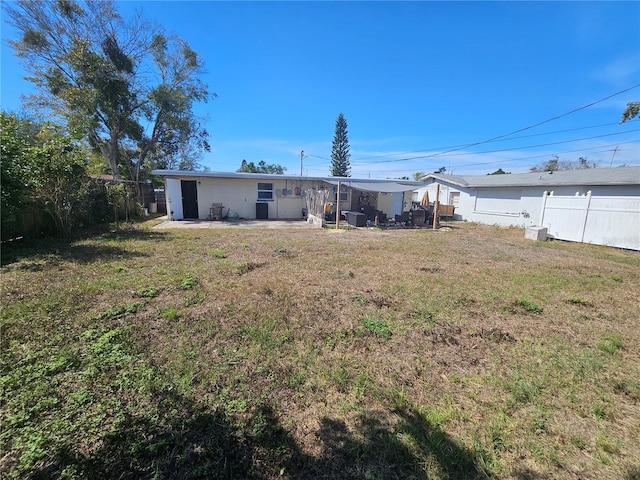 rear view of house with a patio and a lawn