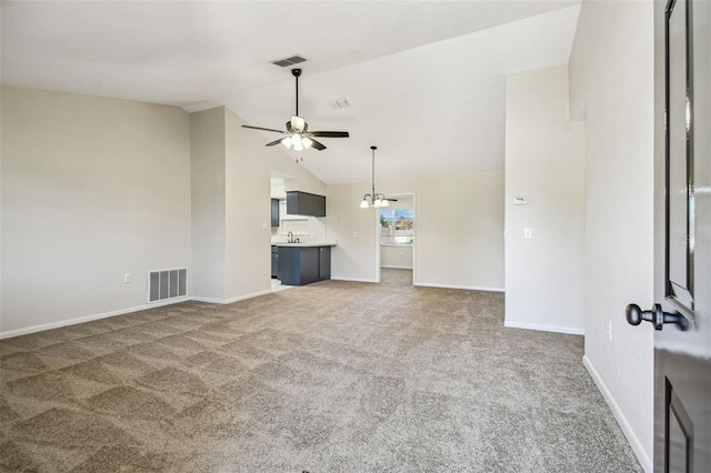 unfurnished living room with ceiling fan, high vaulted ceiling, sink, and dark carpet