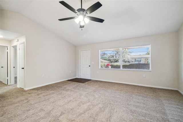 carpeted spare room with ceiling fan and vaulted ceiling