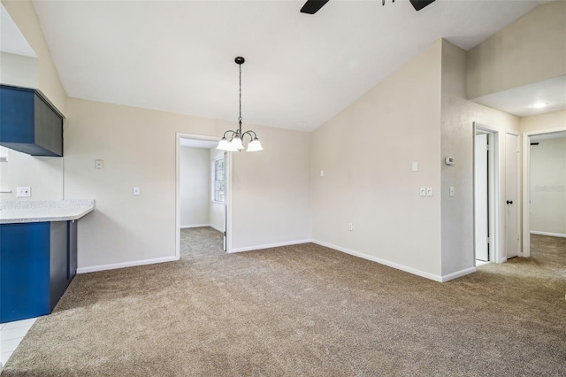 interior space with dark colored carpet, lofted ceiling, and ceiling fan with notable chandelier