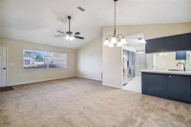 kitchen featuring lofted ceiling, sink, light carpet, stainless steel fridge, and ceiling fan