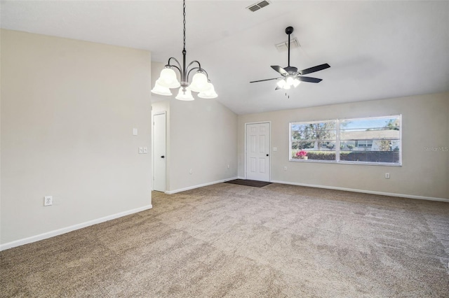 spare room with ceiling fan with notable chandelier, carpet floors, and vaulted ceiling