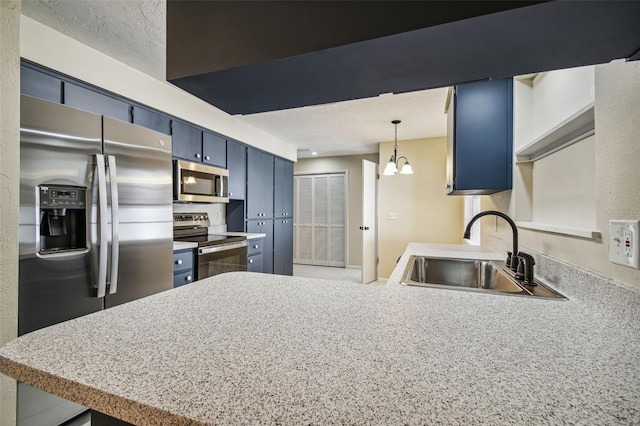 kitchen featuring pendant lighting, sink, blue cabinetry, stainless steel appliances, and kitchen peninsula