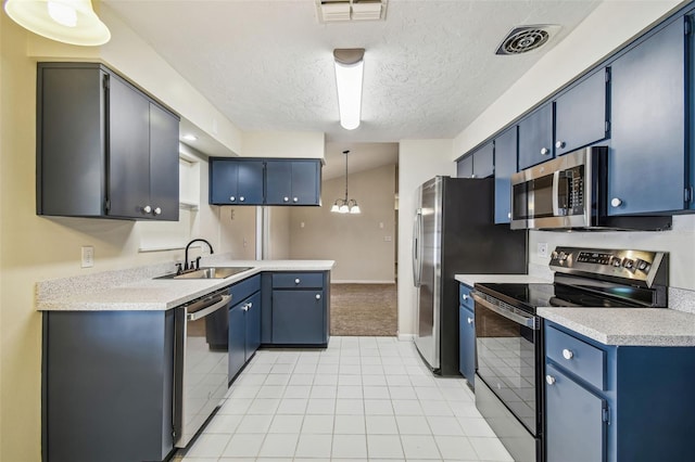 kitchen featuring blue cabinetry, sink, a textured ceiling, pendant lighting, and stainless steel appliances