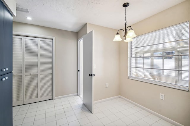 unfurnished dining area featuring light tile patterned flooring, a chandelier, and a textured ceiling