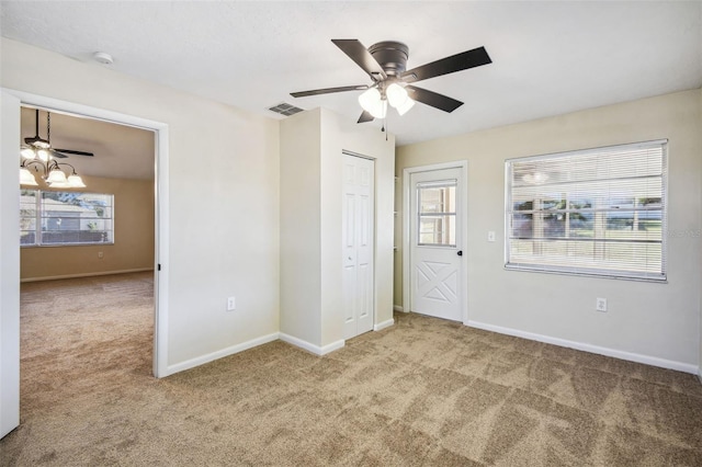 interior space featuring ceiling fan with notable chandelier