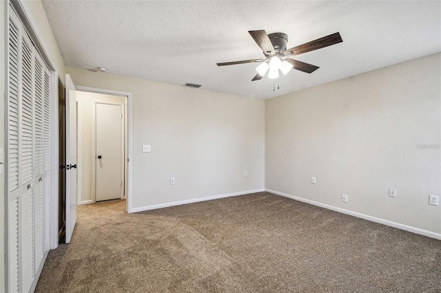 unfurnished bedroom featuring ceiling fan, carpet floors, a textured ceiling, and a closet