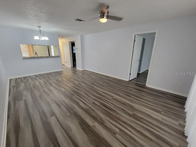 unfurnished living room featuring dark hardwood / wood-style flooring, ceiling fan with notable chandelier, and a textured ceiling