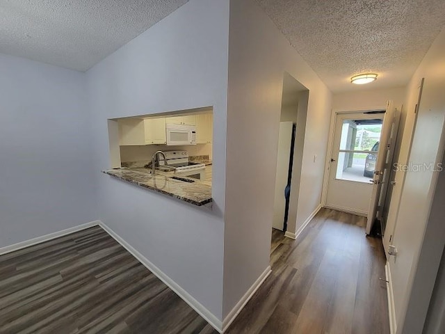 hall with dark wood-type flooring and a textured ceiling