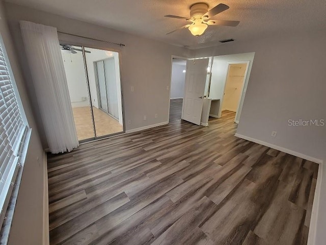 unfurnished bedroom featuring ceiling fan, hardwood / wood-style floors, and a textured ceiling