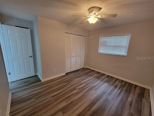 unfurnished bedroom featuring dark hardwood / wood-style flooring, ceiling fan, a closet, and a textured ceiling