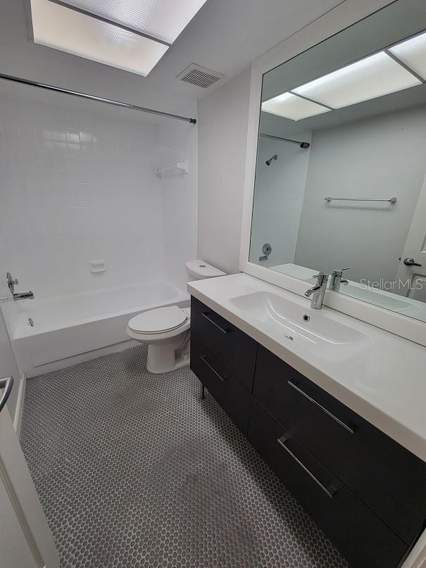 full bathroom with vanity, bathtub / shower combination, tile patterned floors, and toilet