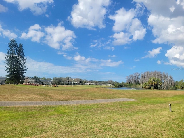 surrounding community featuring a water view and a lawn