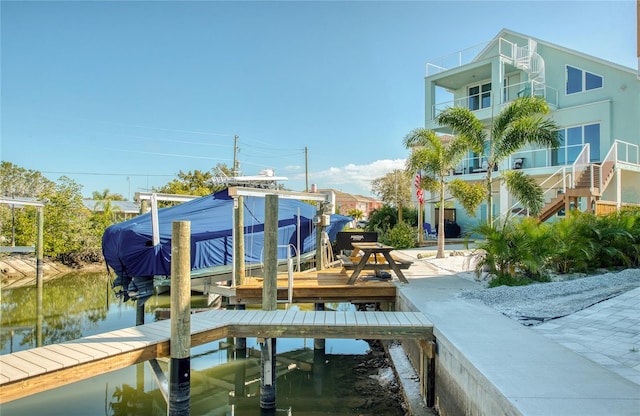 view of dock featuring a water view and a balcony