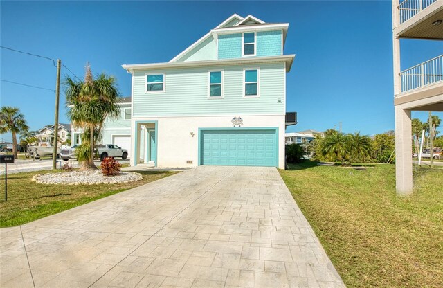 beach home featuring a front yard and a garage