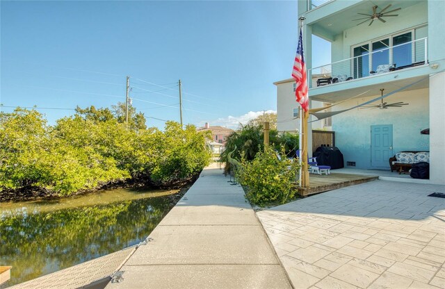 view of home's community with a water view and a patio area