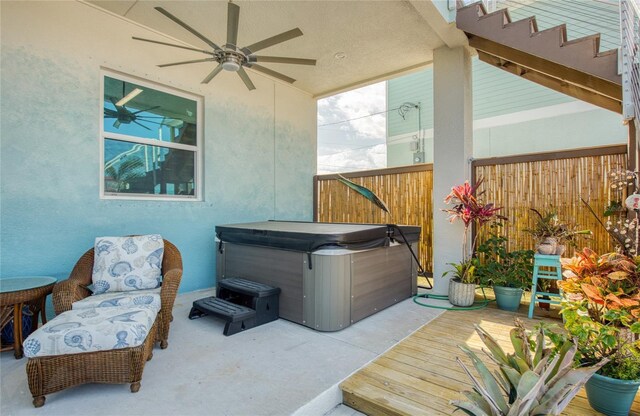 view of patio featuring a hot tub, a deck, and ceiling fan