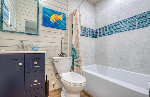 full bathroom with toilet, wood walls, shower / bath combo, hardwood / wood-style floors, and vanity