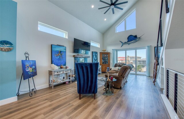 living room with high vaulted ceiling, hardwood / wood-style floors, and ceiling fan