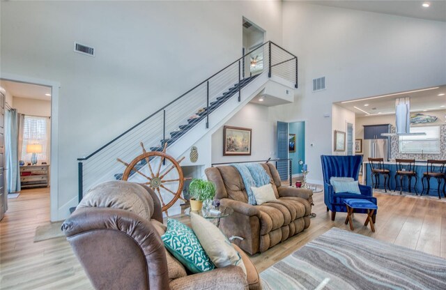 living room with light hardwood / wood-style flooring and a high ceiling