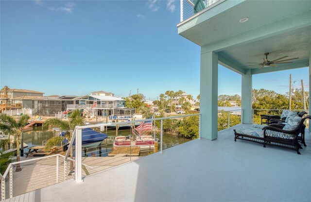 view of patio with a water view and ceiling fan