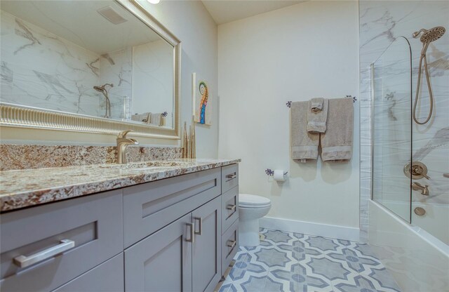 full bathroom featuring tiled shower / bath combo, vanity, tile patterned flooring, and toilet