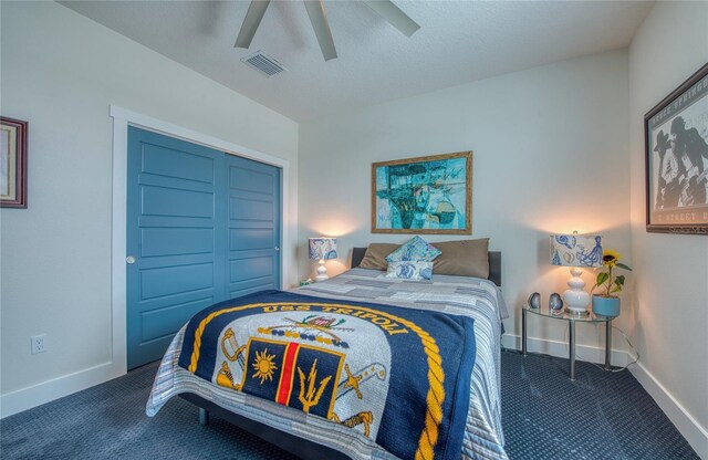 carpeted bedroom with ceiling fan, a textured ceiling, and a closet