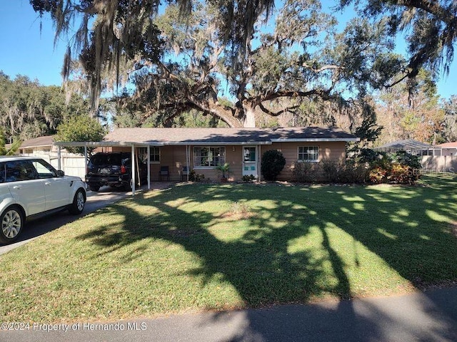 ranch-style home featuring a front lawn and a carport