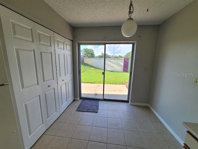 entryway with a textured ceiling and light tile patterned floors