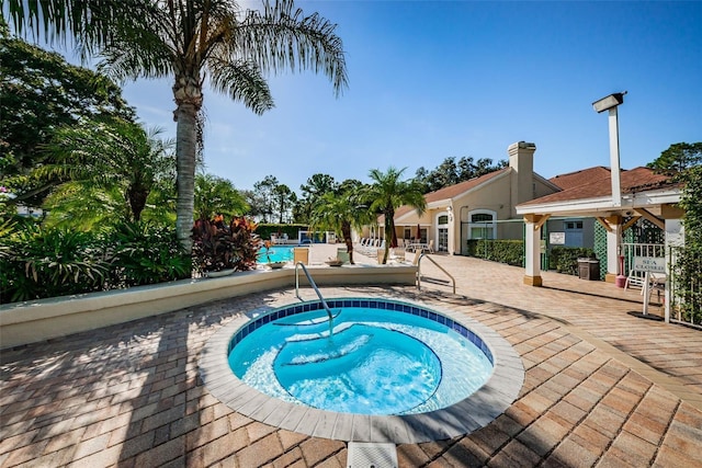 view of pool featuring a patio area and a hot tub