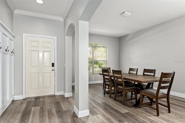 dining room featuring ornamental molding and light wood-type flooring