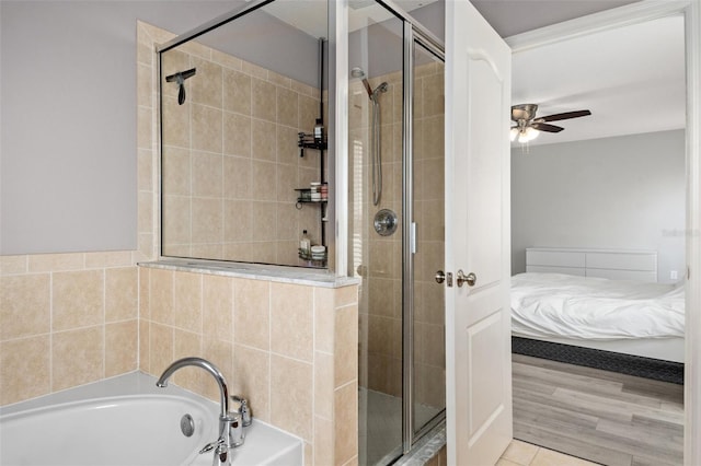 bathroom featuring separate shower and tub and ceiling fan