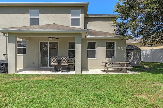 rear view of house with a yard, a patio area, ceiling fan, and a storage unit