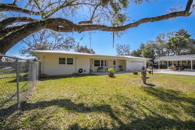 view of front facade featuring a carport, a garage, and a front lawn