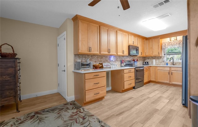 kitchen featuring sink, stainless steel appliances, light brown cabinetry, decorative backsplash, and light wood-type flooring