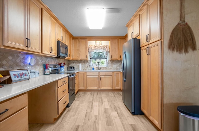 kitchen with sink, light hardwood / wood-style flooring, light brown cabinets, stainless steel appliances, and decorative backsplash