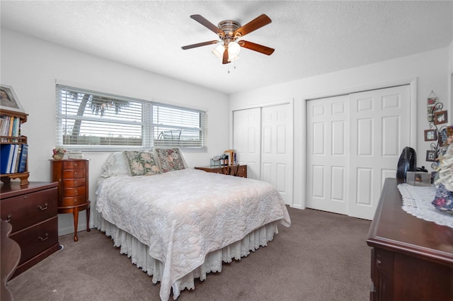 carpeted bedroom featuring multiple closets, ceiling fan, and a textured ceiling