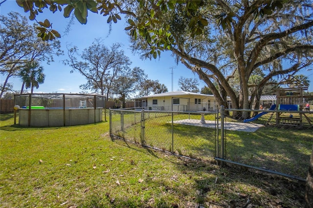 view of yard with a fenced in pool and a playground