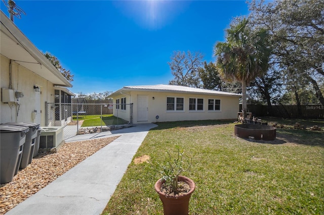 rear view of house featuring a yard and a fire pit