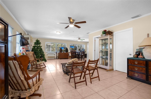 dining room featuring ceiling fan, ornamental molding, and light tile patterned floors