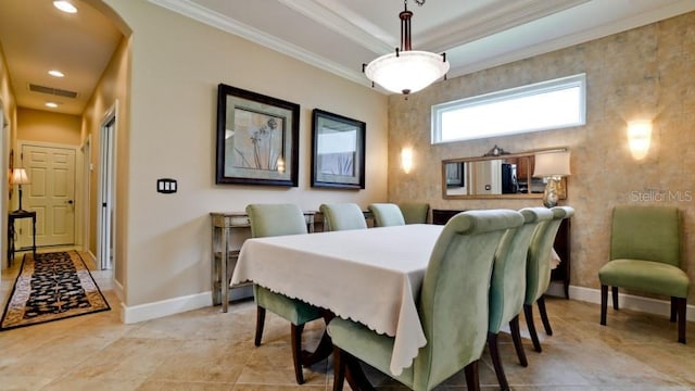 dining space with a raised ceiling, crown molding, and light tile patterned flooring