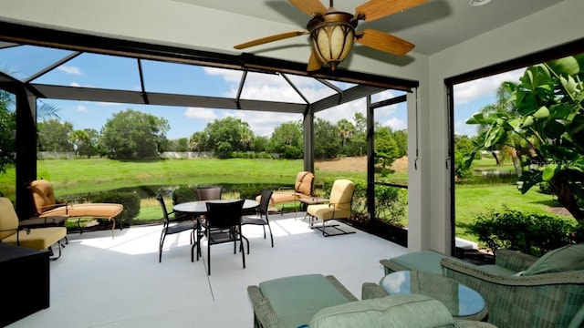 sunroom with a water view and ceiling fan