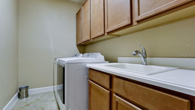 laundry room with cabinets, separate washer and dryer, and sink