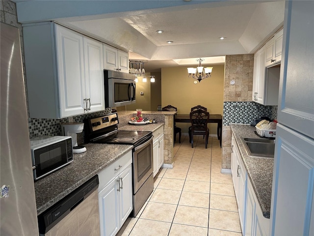 kitchen with stainless steel appliances, pendant lighting, and white cabinets