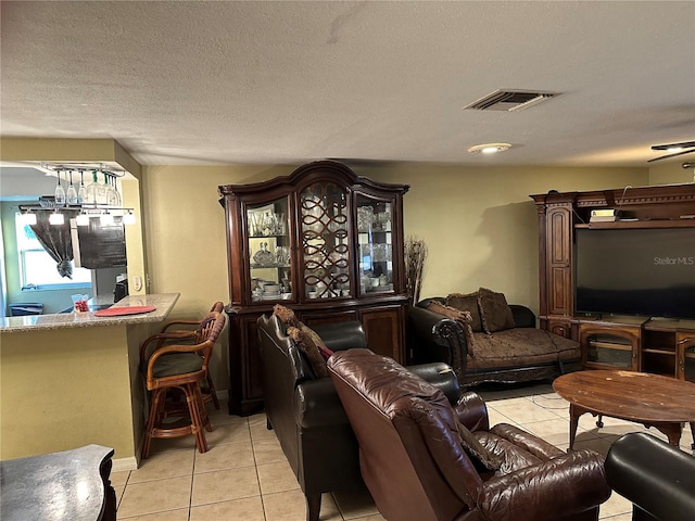 living room featuring a textured ceiling and light tile patterned flooring