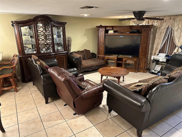 tiled living room with a textured ceiling and ceiling fan