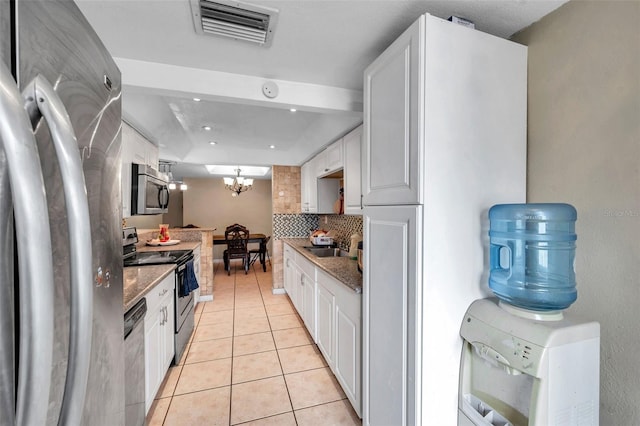 kitchen with light tile patterned floors, visible vents, white cabinetry, appliances with stainless steel finishes, and tasteful backsplash