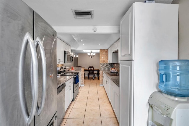 kitchen with stainless steel appliances, light tile patterned flooring, visible vents, and white cabinets