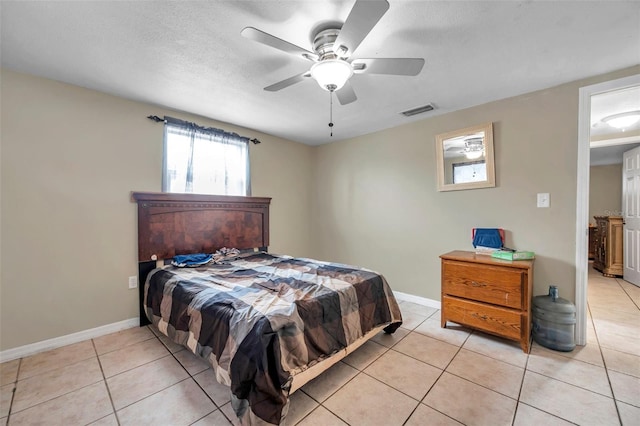 bedroom with light tile patterned floors, baseboards, visible vents, and a textured ceiling