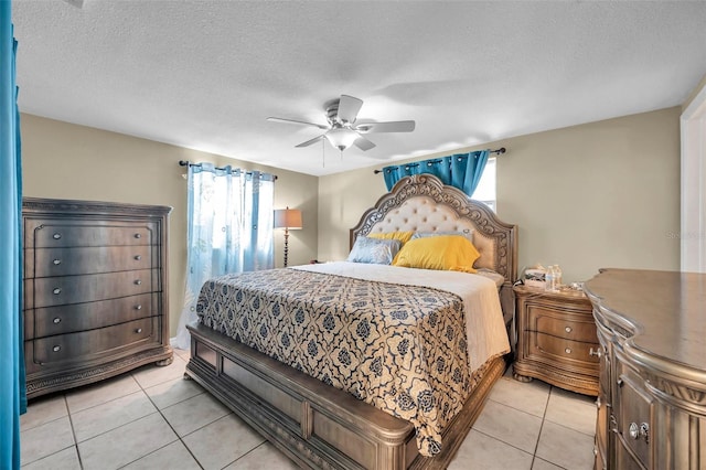 bedroom featuring light tile patterned floors, ceiling fan, and a textured ceiling